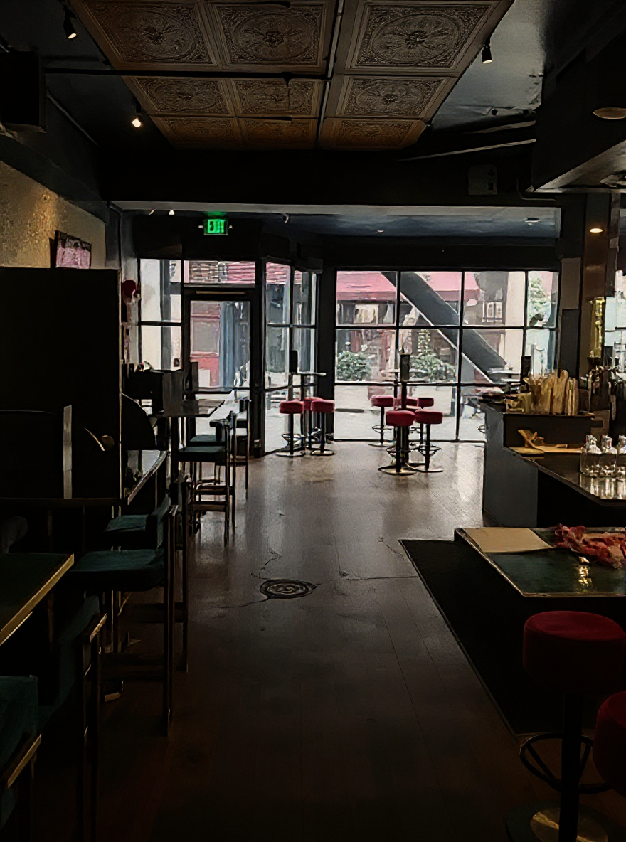 Barbary Belle main floor — pressed tin ceiling, warm Edison lighting, full room view